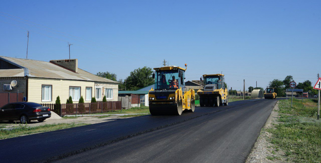 На последнем ненормативном участке автоподъезда в Питерском районе укладывают асфальтобетон